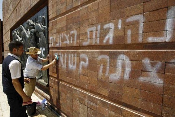 Funcionários do Museu do Holocausto limpam as pichações nesta segunda-feira (11) em Jerusalém (Foto: AFP)