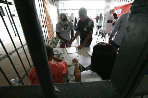Imagem: preso votando Mais de 14 mil presos provisórios e jovens infratores votam em outubro