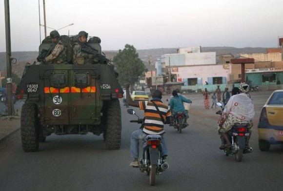 Tropas francesas passam por moradores da capital do Mali, Bamako, nesta terça-feira (15) (Foto: Jerome Delay/AP)