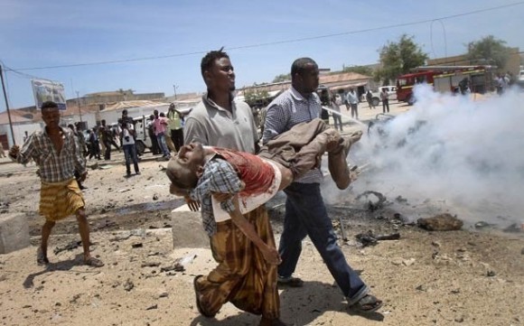 Ferido é retirado do local do ataque nesta segunda-feira (18) em Mogadício, capital da Somália (Foto: AP)