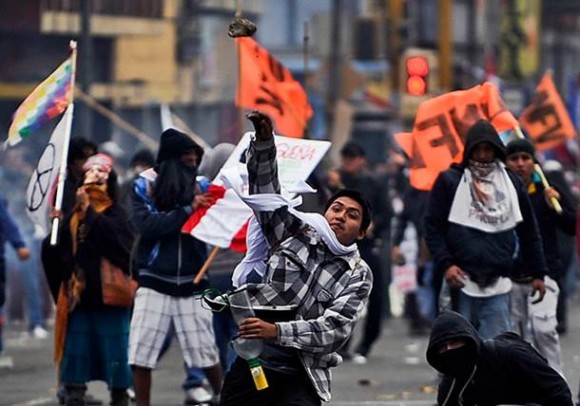 Manifestante joga pedra contra polícia durante protesto em Lima, no Peru (Foto: Ernesto Benavides/AFP)
