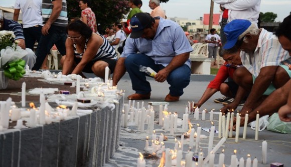 População acendendo velas para entes que já partiram - Foto: Ronaldo Teixeira / AGORA MT
