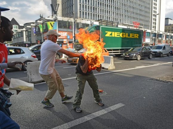 Um homem coloca fogo em si mesmo durante manifestação de imigrantes em Bruxelas, na Bélgica (Foto: Thibalt Kruyts/AFP)Um homem coloca fogo em si mesmo durante manifestação de imigrantes em Bruxelas, na Bélgica (Foto: Thibalt Kruyts/AFP)