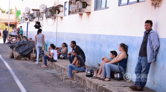 Pessoas esperam sentados no chão próximo a pista de testes - Foto: Ronaldo Teixeira / AGORA MT