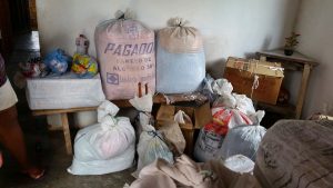 Pertences da família de dona Alcinda organizados em sacos de ração e caixas - Foto: Você-repórter