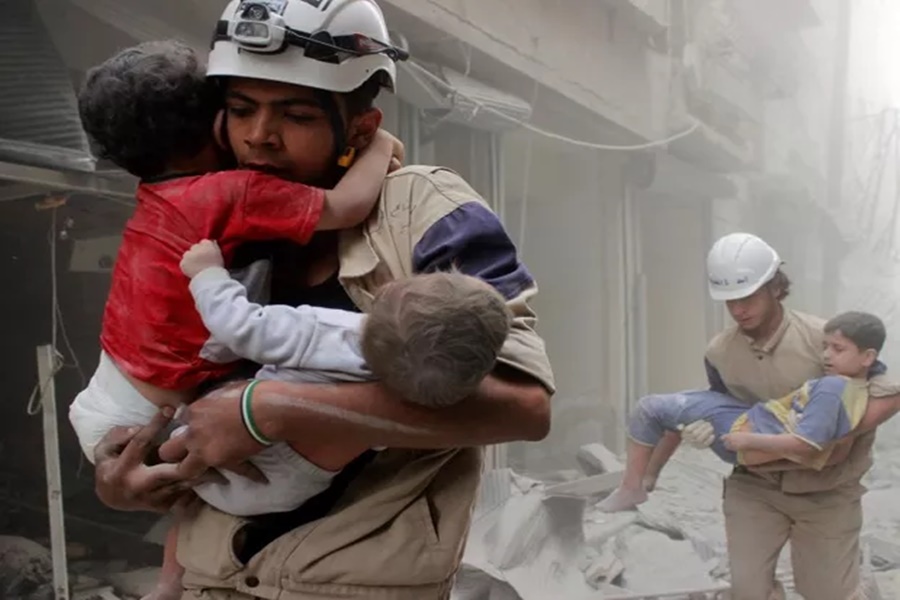Imagem: Membros da Defesa Civil resgatam crianças após ataque aéreo na cidade síria de Aleppo
