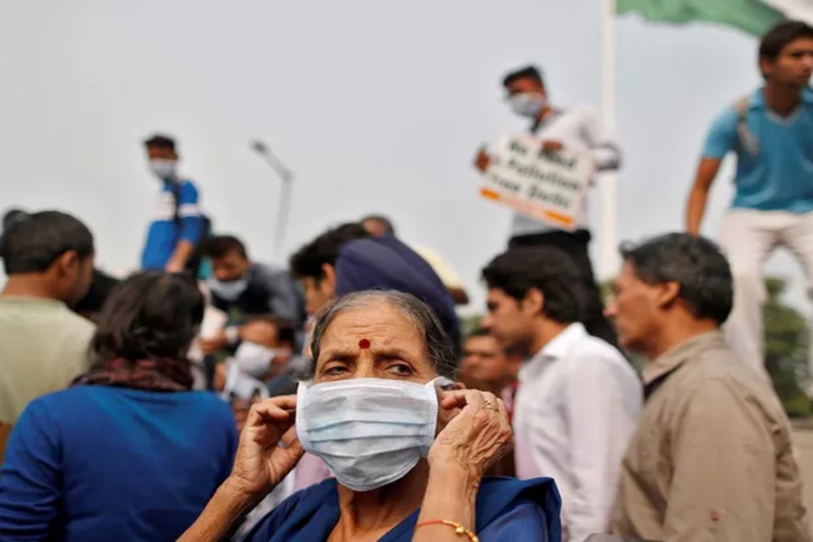 Imagem: Mulher usa máscara para se proteger da poluição durante um protesto em Déli
