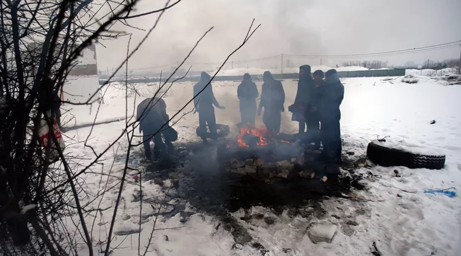 Imagem: pessoas se aquecendo em fogueira no frio da Europa
