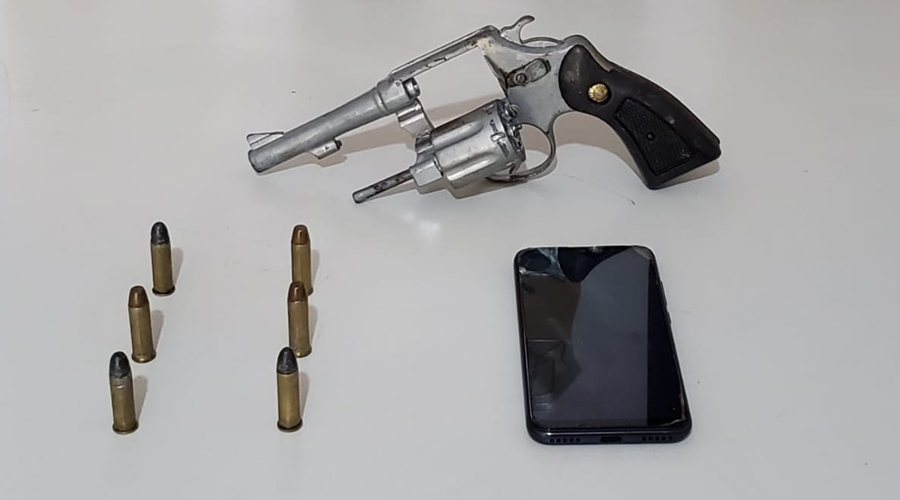 Imagem: Arma municoes e celular apreendido com os suspeitos Jovem de 18 anos é preso andando com revólver na cintura
