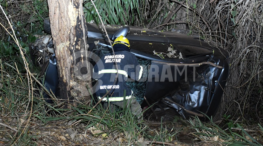 Imagem: Militar do Coirpo de Bombeiros analisando a situacao no veiculo Empresário e idoso morrem após carro capotar ao atropelar anta na BR-364